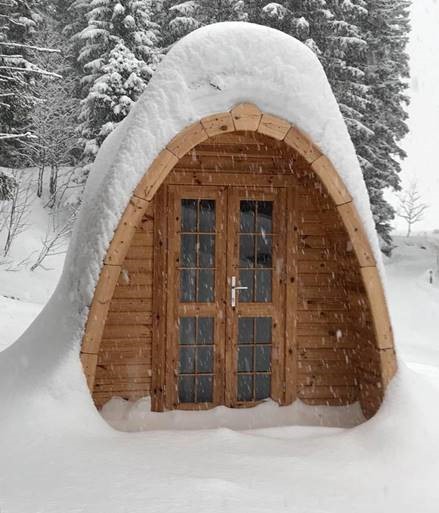 Bungalow POD in legno ricoperto di neve durante l’inverno