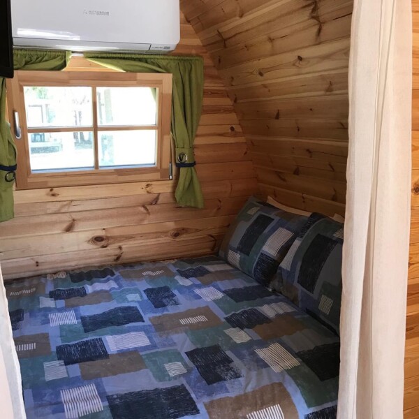 Zona notte interna del Bungalow POD in legno con finestra