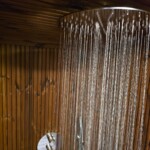 Sauna da esterno con doccia integrata e grande vetrata panoramica