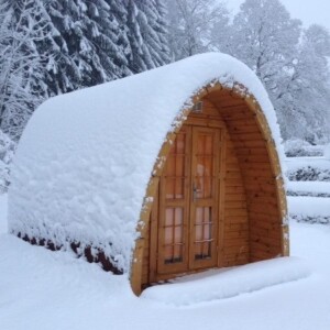 Camping POD in legno installato sulla neve durante l’inverno