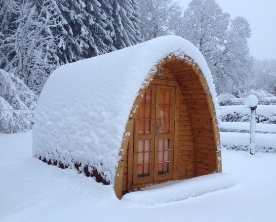 Camping POD in legno installato sulla neve durante l’inverno
