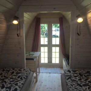 Interno del Camping POD in legno con illuminazione e porta vetrata