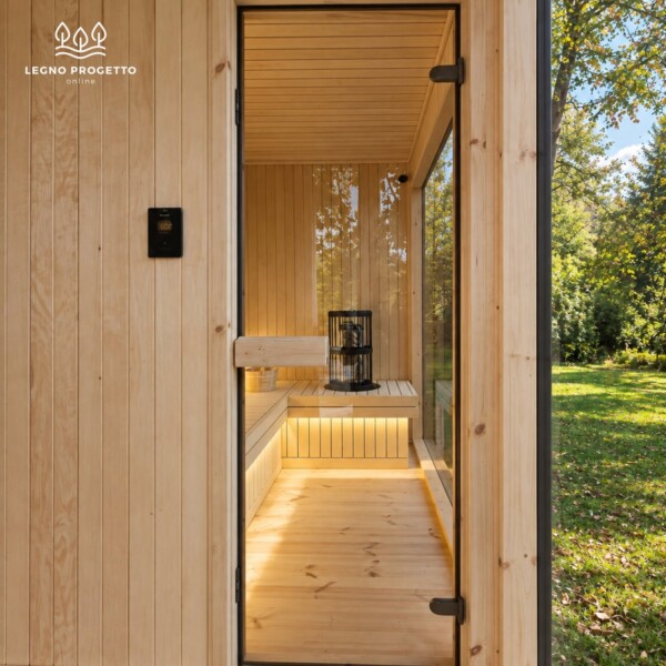 Ingresso della sauna FRAME in legno con stufa e panche illuminate all’interno