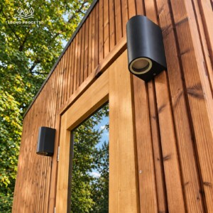 Dettaglio del rivestimento esterno in legno della sauna FRAME con applique nera